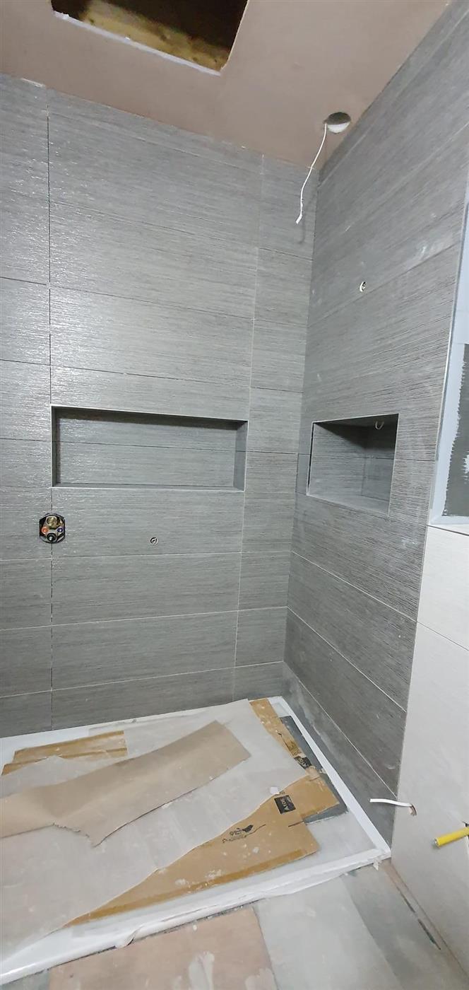 Grey tiled shower with recessed niche by Kew Construction, Liverpool