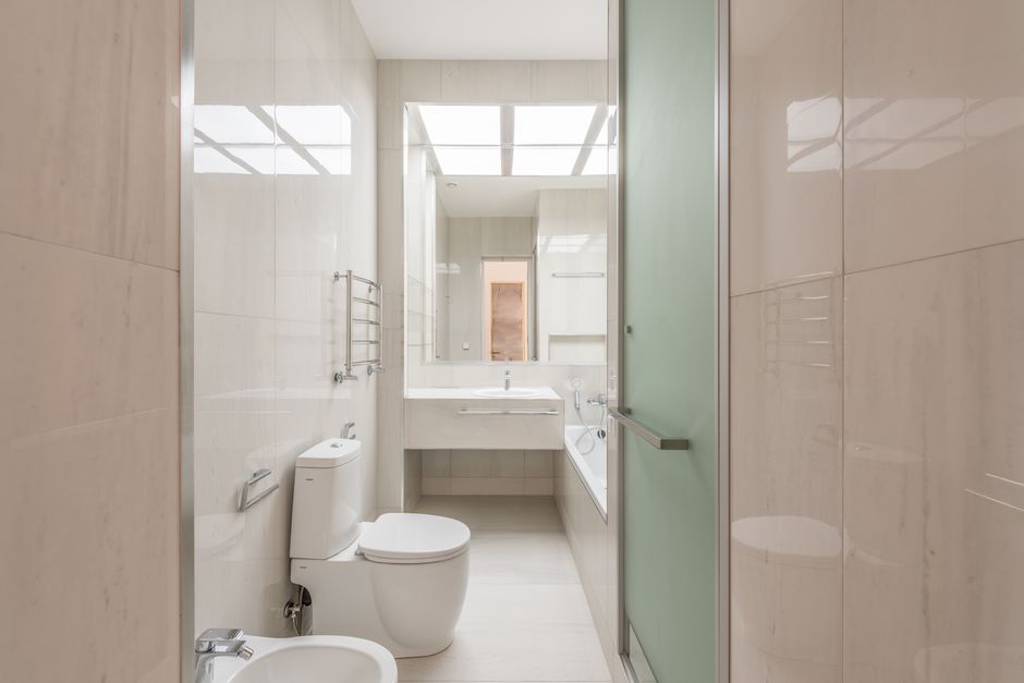 Completed loft ensuite bathroom installation in a Formby home showing walk-in shower, close-coupled toilet and tiled walls