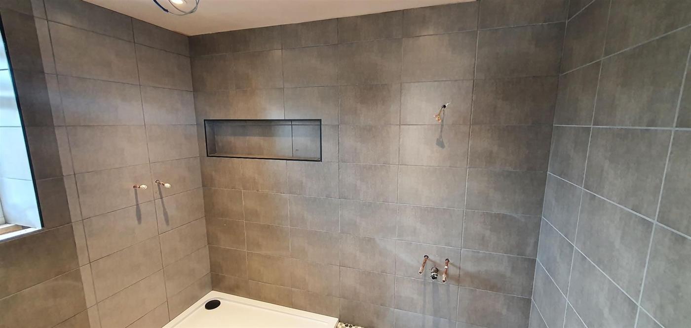 Walk-in shower tiled in large grey tiles by Kew Construction, Liverpool
