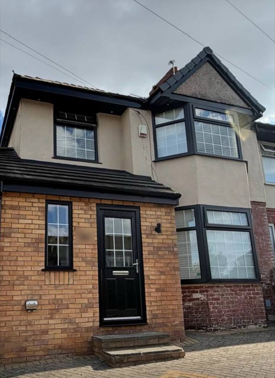 Exterior house renovation Liverpool: rendered upper walls, black uPVC windows, composite door and brick porch